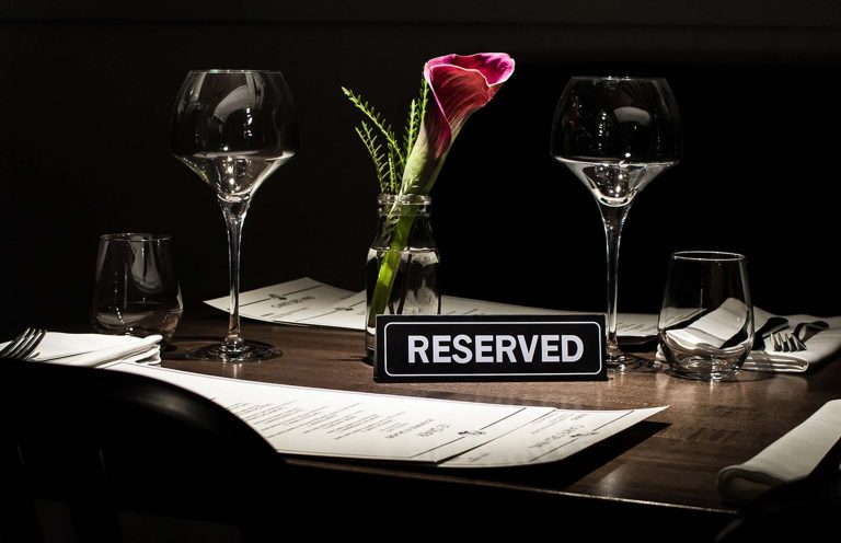 Image: A vibrant scene showcasing a reserved table at a restaurant. Our restaurant advertising service helps you attract more customers and enhance your dining experience. Visit www.cyrusmedia.ca/restaurant-advertising for more information