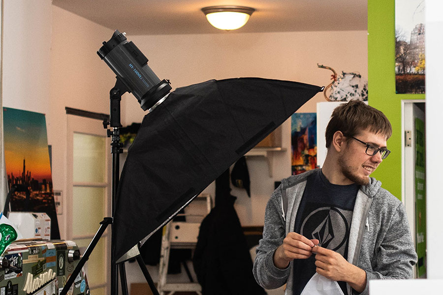 Cyrus Media crew member setting up studio lights for a commercial video production shoot.