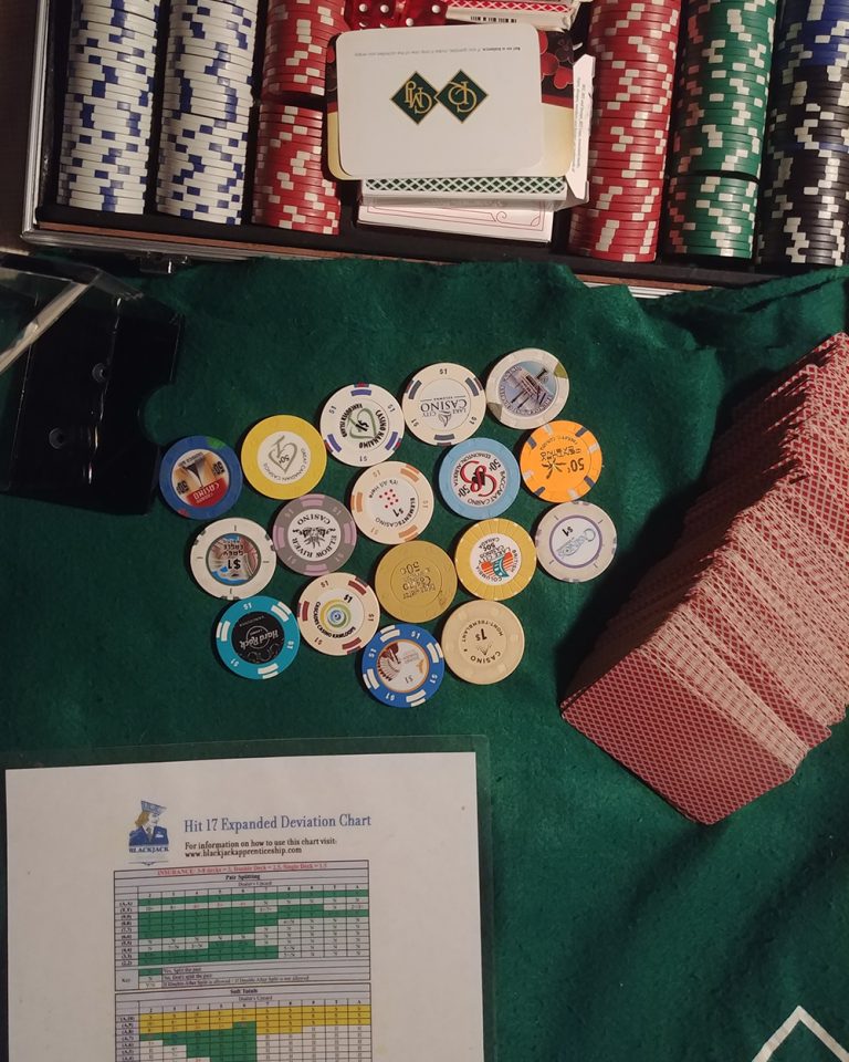 Blackjack felt with cards, chips, discard tray, and deviation charts laid out, illustrating my card counting training routine.