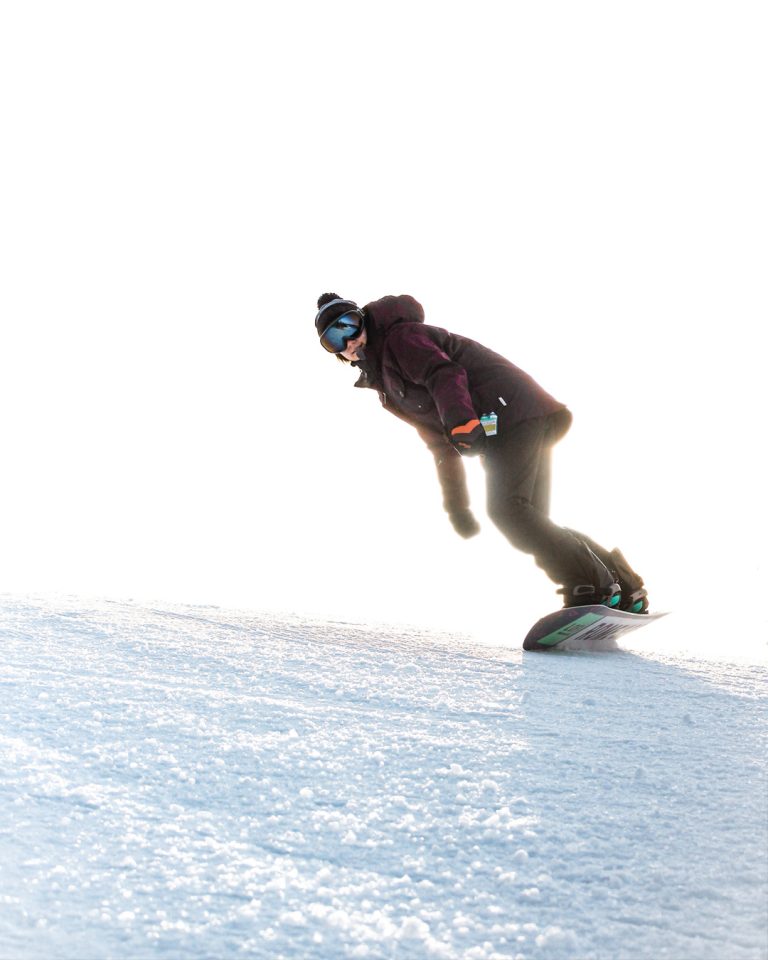 Woman snowboarding down a hill at Mt. Pakenham, photographed by Cyrus Media in Ottawa, Ontario.