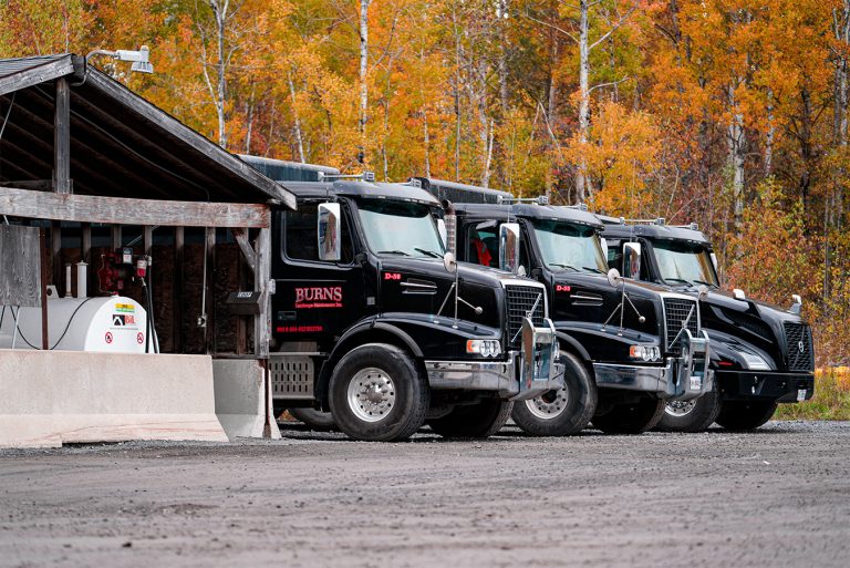 “Burns Landscaping dump trucks parked during autumn, photographed by Cyrus Media — professional commercial photography and video production for industrial, construction, and landscaping companies.